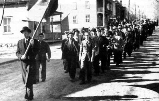 Les ouvriers grévistes défilant dans les rues d'Asbestos.